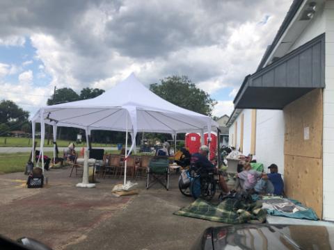 Evicted by Mayor of Brunswick from its own facility, St. John's Baptist Church now gathers under a tent outside its usual santuary.